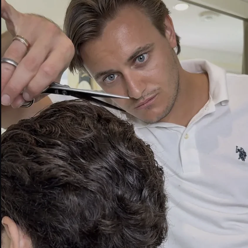 Vlad Barsky cutting a client’s hair with scissors in Miami Beach