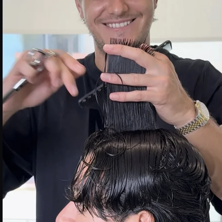 Vlad Barsky cutting a client’s hair with scissors in Miami Beach